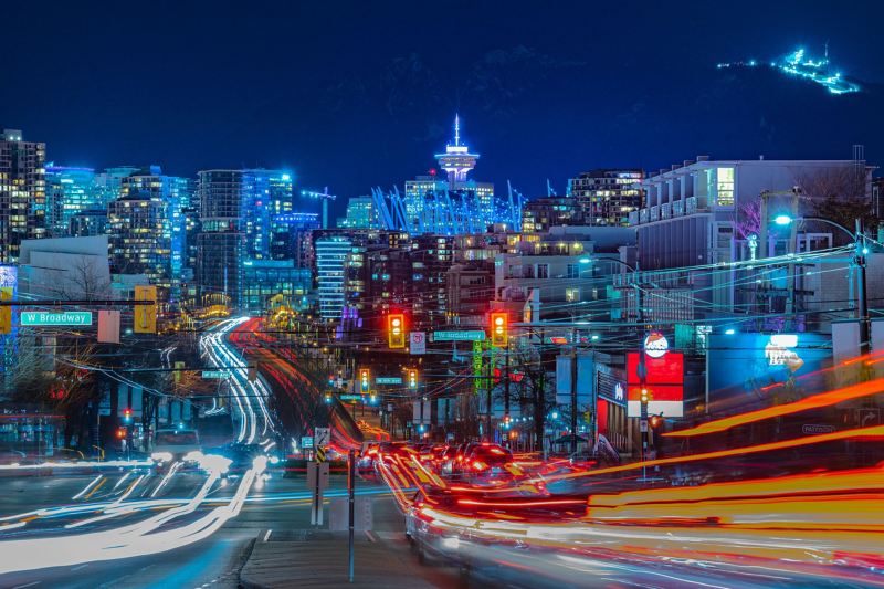 Bei Nacht sieht man die kanadische Stadt Vancouver, auf dessen Straßen viele Autos unterwegs sind