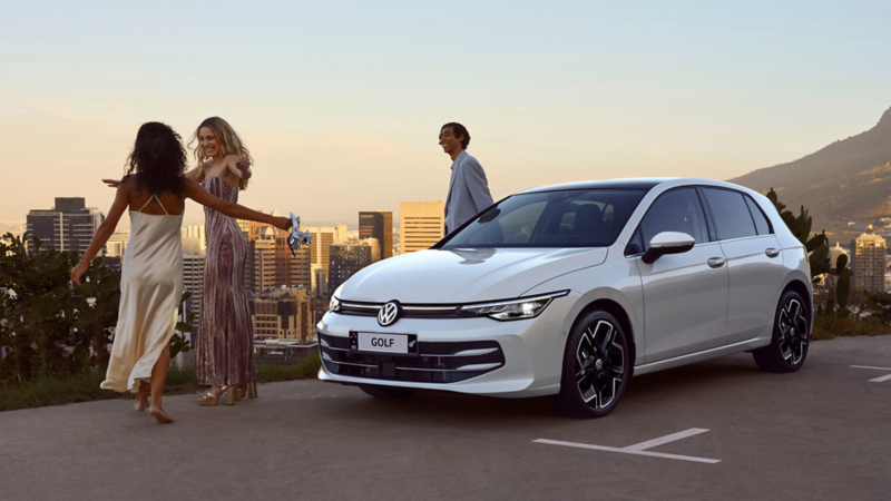 People hugging in front of VW Golf