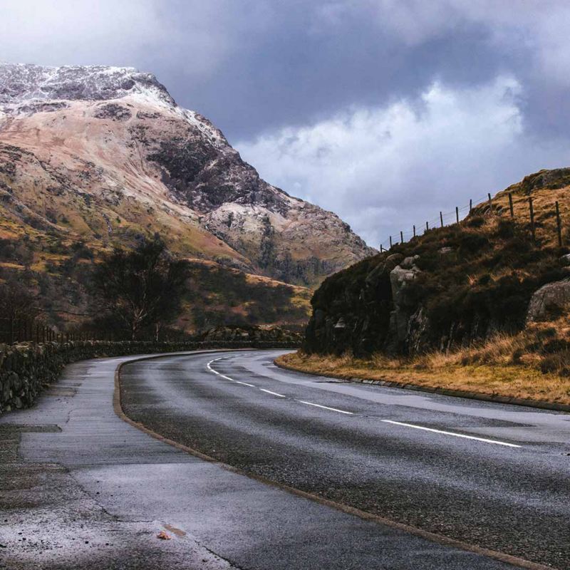 Carretera húmeda en medio de paisaje frío en invierno.