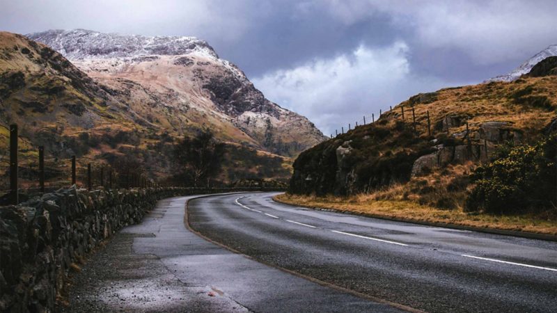 Carretera húmeda en medio de paisaje frío en invierno.