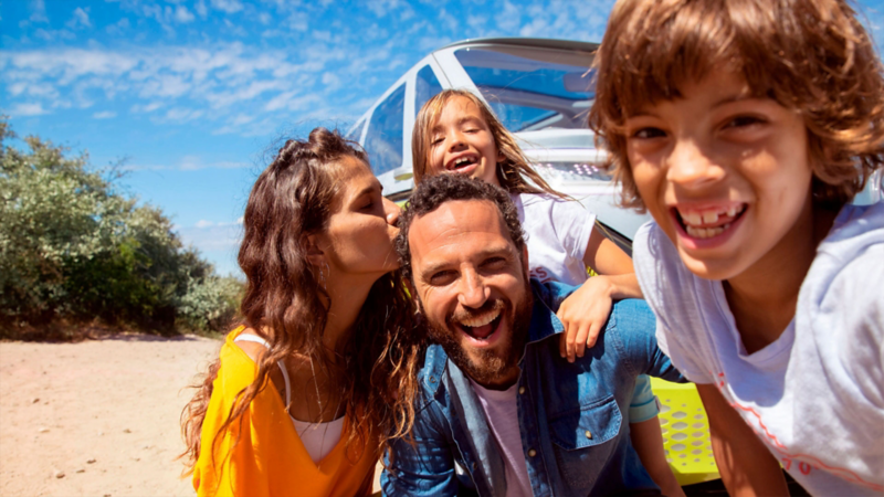 Familia en playa, de fondo Volkswagen ID. Buzz 