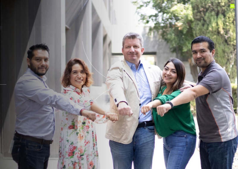 Miembros de Volkswagen México acercan sus puños para trabajar en equipo. 