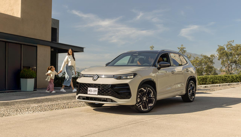 Mama e hija caminan hacia una camioneta Tiguan 2025 de Volkswagen, en color exterior blanco.