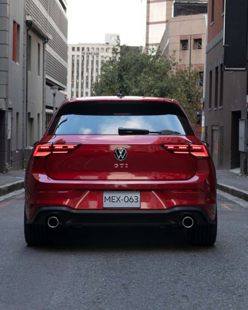 Logo VW en la parte trasera de Golf GTI 2024, modelo deportivo en color rojo.