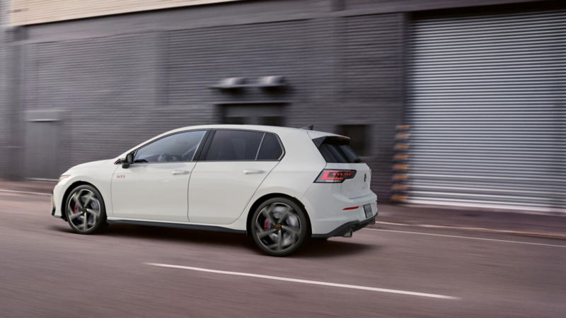 Golf GTI 2024 en color rojo circula dentro de avenida en la ciudad. 