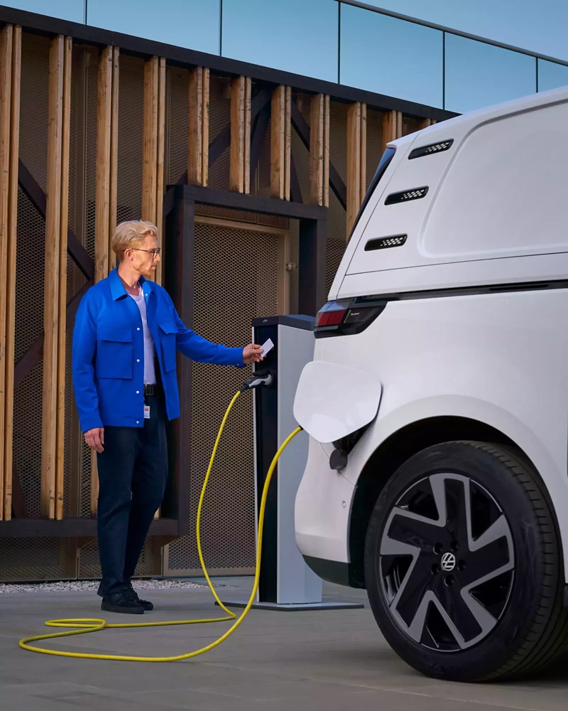 The ID. Buzz Cargo being connected to a charging unit by a man