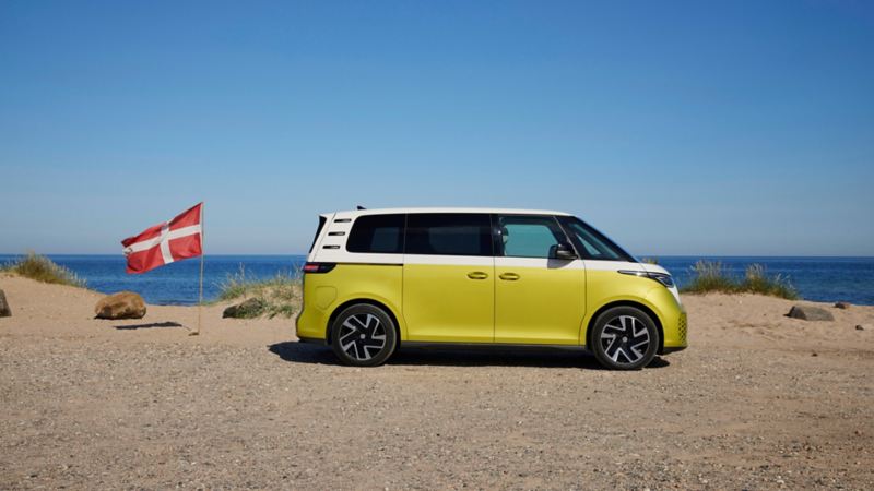 VW ID. Buzz på stranden bredvid danska flaggan
