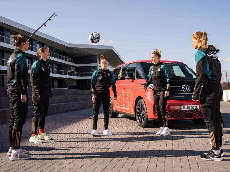 Fünf Frauen der DFB Frauen Auswahl halten einen Fußball in der Luft.