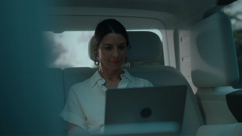 Sandra Runge siede sul retro di un Volkswagen ID. Buzz con un laptop.