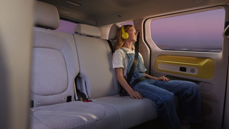 VW ID. Buzz – matkustaja kuuntelee musiikkia takapenkillä