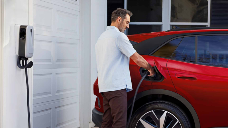 Conductor de ID 4 carga su auto eléctrico desde un centro de carga casero.