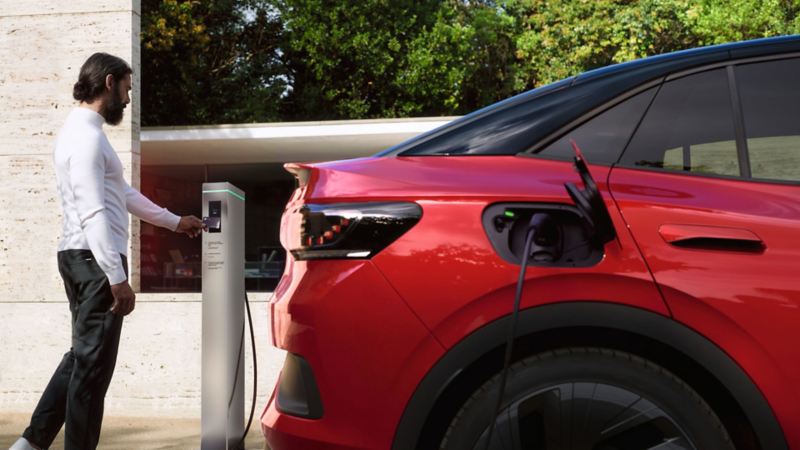 Man holds charging card at charging station