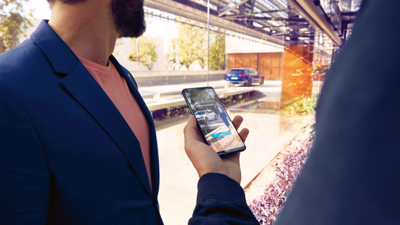 Hombres utilizando su teléfono celular con tecnología Volkswagen