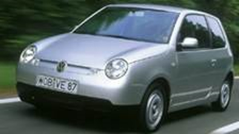 Schuin vooraanzicht van een oude grijze Volkswagen Lupo die rijdt op de weg
