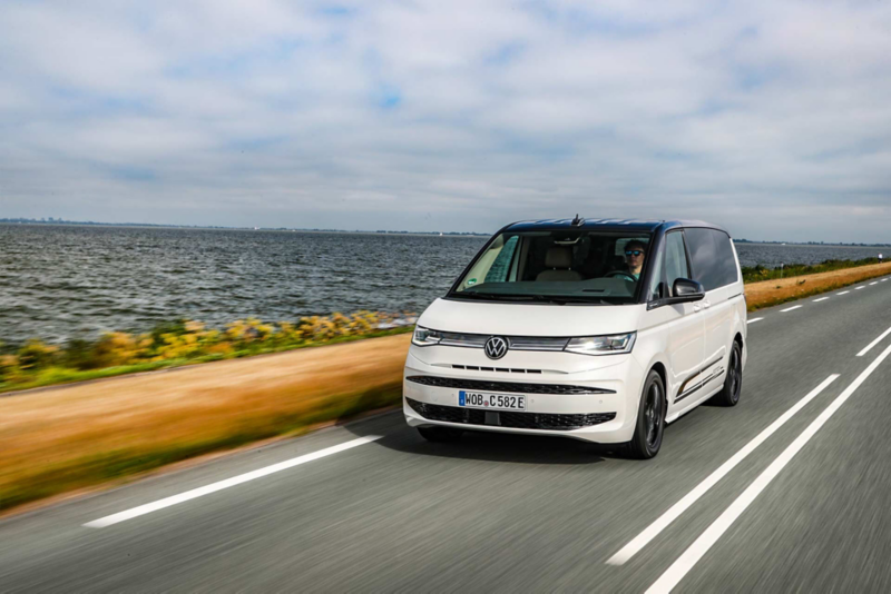 VW Multivan eHybrid kör längs ett hav.
