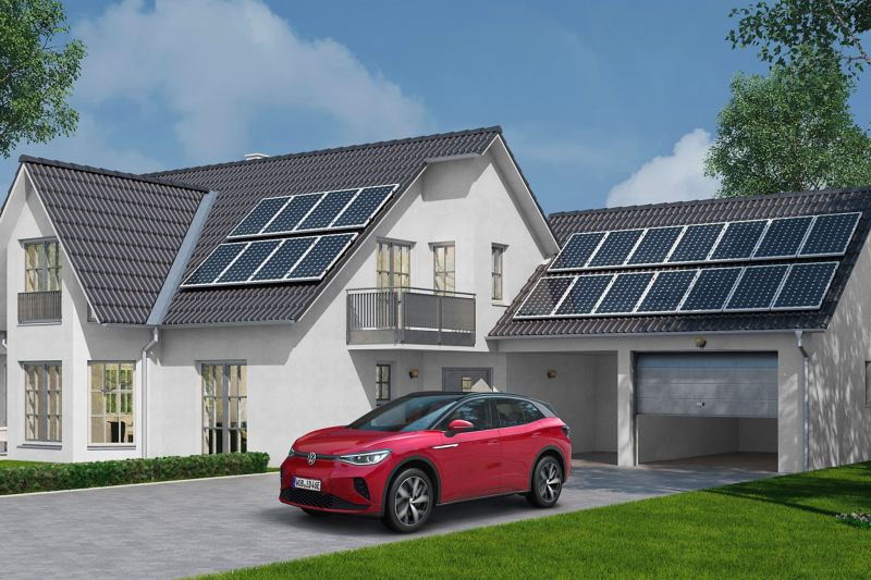 Ein roter ID.4 parkt vor einem Wohnhaus mit Solarzellen auf dem Dach des Hauses und der Garage.