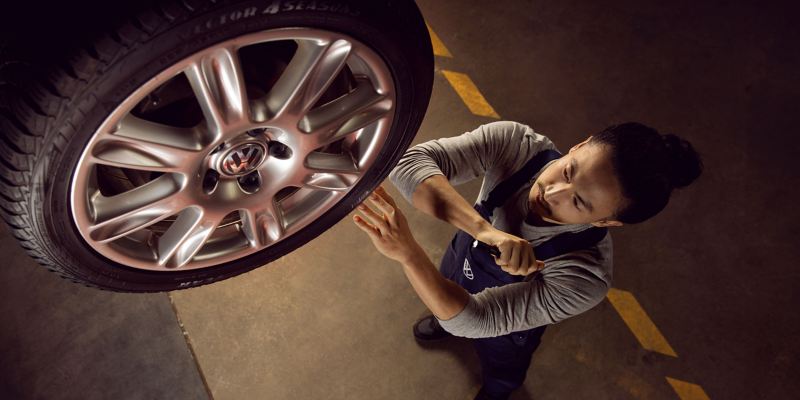 Un colaborador de VW Servicio revisa un neumático