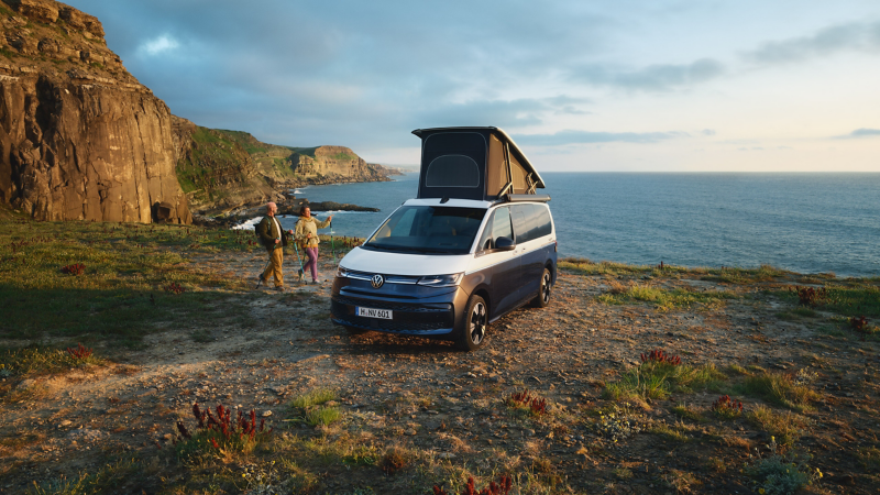 Due veicoli VW California affiancati con il tetto sollevato e le porte scorrevoli aperte.