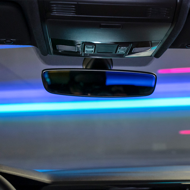 Espejo retrovisor de Nivus 2024, con luces de neón que iluminan el exterior de SUV.