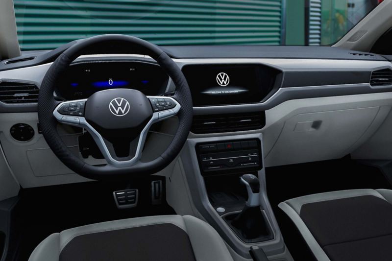 Interior de T Cross. Camioneta SUVW con volante multifunciones, pantallas, panel de clima y cargador inalámbrico. 