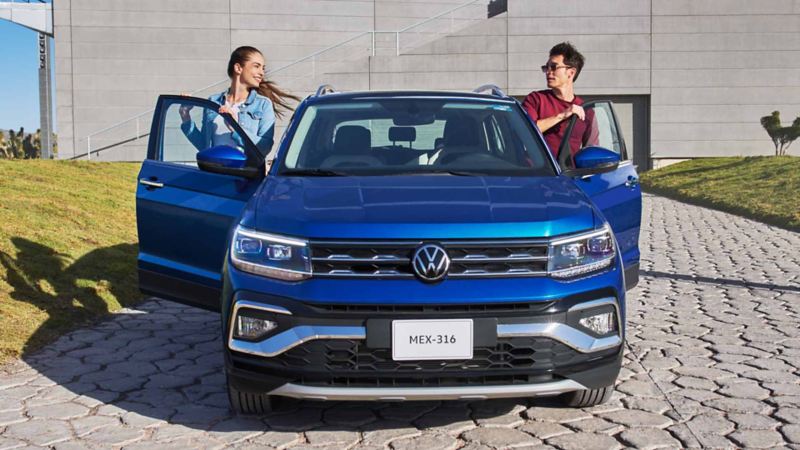 Dos chicos abordan un Nuevo Taigun 2023, la nueva camioneta SUV de Volkswagen. 