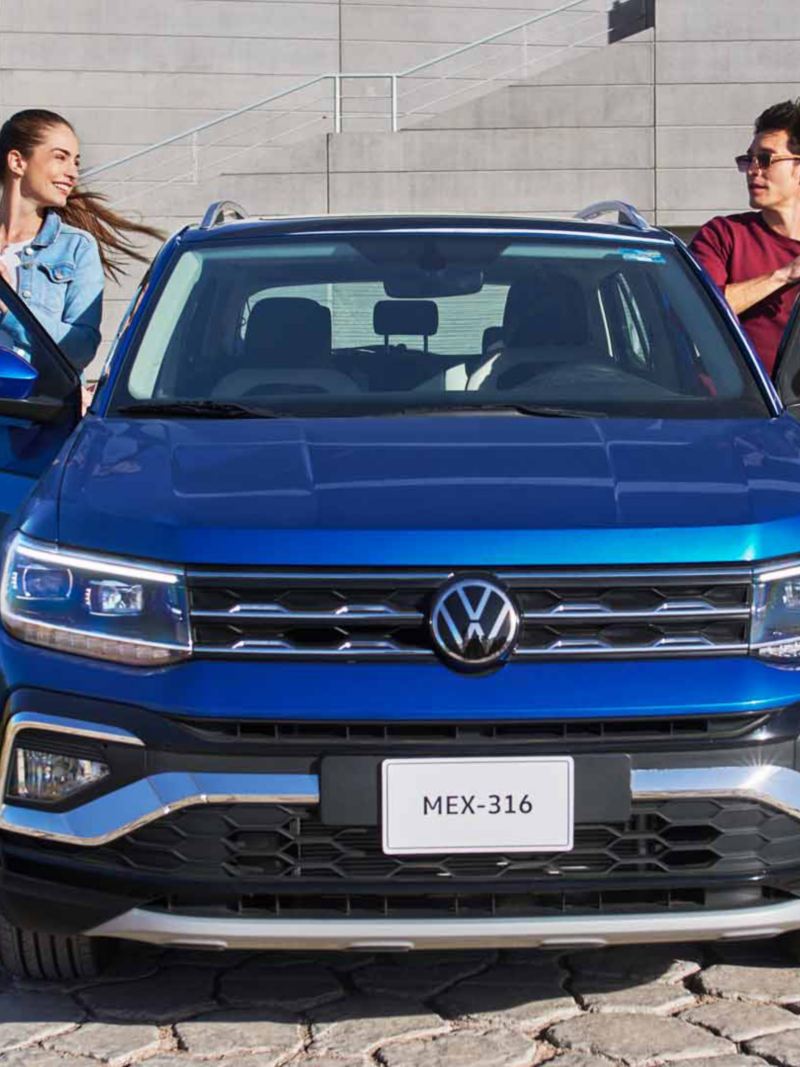 Dos chicos abordan un Nuevo Taigun 2023, la nueva camioneta SUV de Volkswagen. 