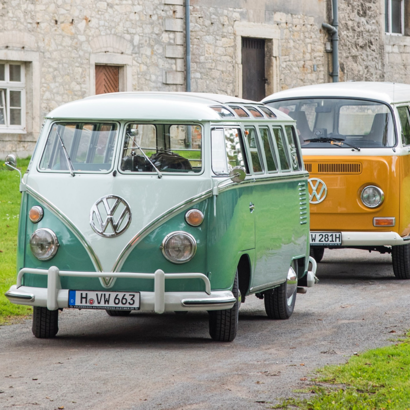 Zwei VW Oldtimer auf einem Feldweg.