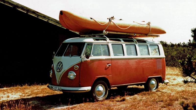 Ein Volkswagen T1 schräg von vorne mit Boot auf dem Dach.