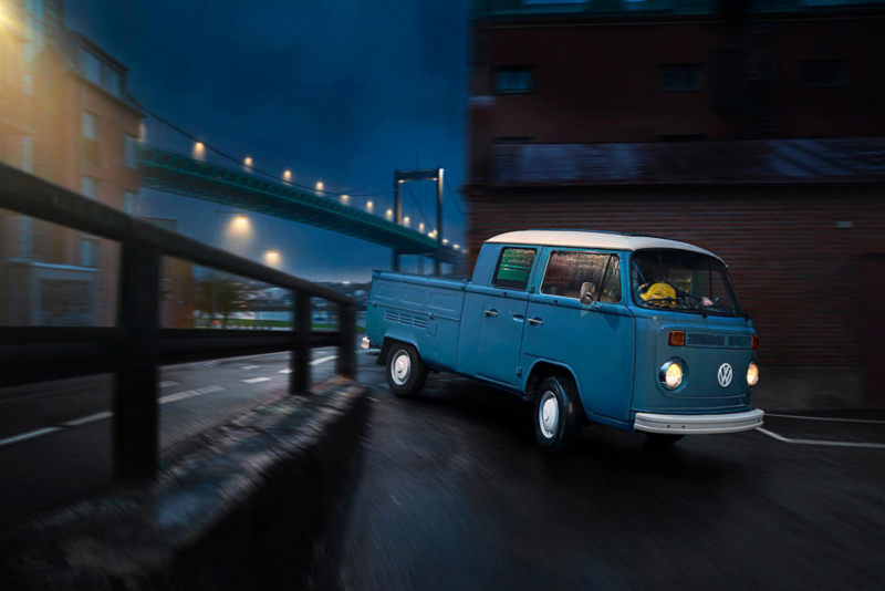 En duvblå VW pickup 1973 års modell i Göteborgs varv med Älvsborgsbron i bakgrunden