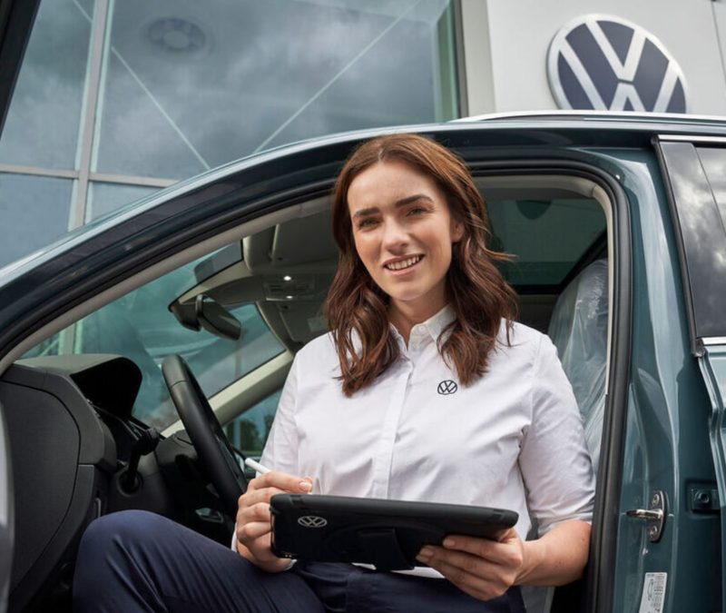 Imagen de una mujer representante de VW detallando la garantia del auto moderno VW Polo Track