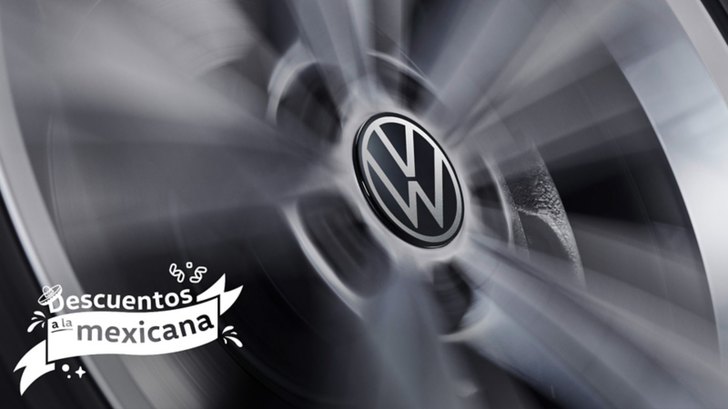 Primer plano de una llanta Volkswagen girando, con el logo VW central.