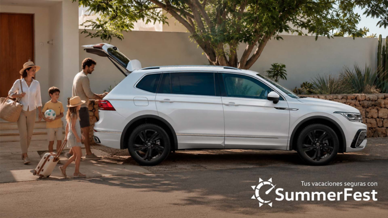 Volkswagen Tiguan de color blanco. Familia guarda equipaje en cajuela, con logo Summer Fest.