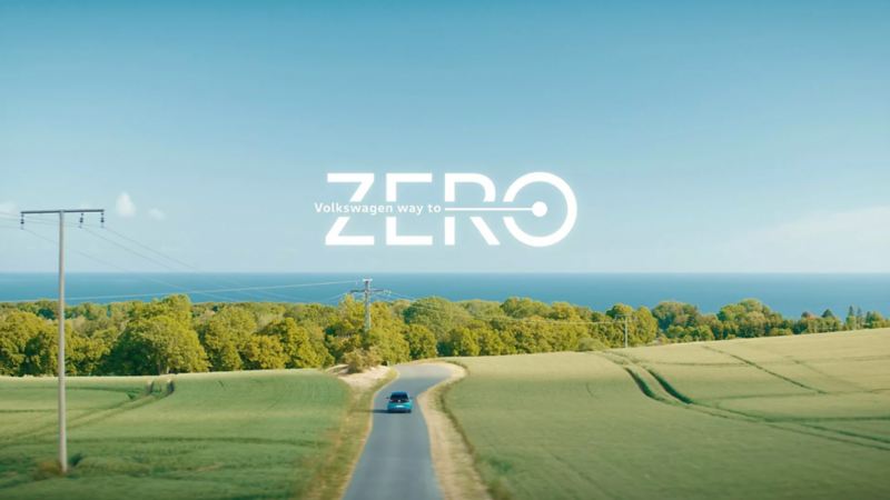 way to ZERO: Ein VW ID.3 fährt durch eine grüne Landschaft Richtung Meer.