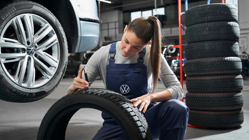 Técnica de Volkswagen checa una llanta dentro del taller de mantenimiento.