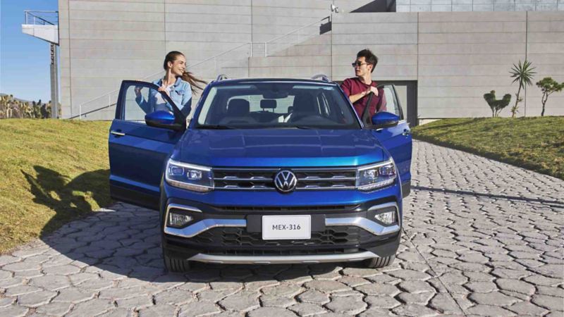 Dos personas ingresan al interior de Volkswagen Taigun, edición  en color azul. 