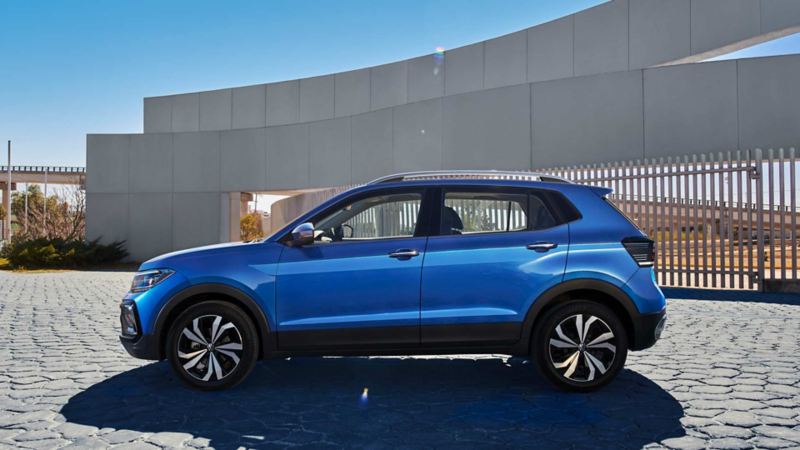 Taigun 2023 México - SUV de Volkswagen en color azul, estacionada cerca de estructura moderna. 