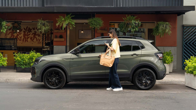 Mujer sube a SUV Taigun 2026 al abrir la puerta de conductor. 