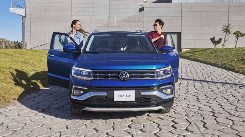 Dos personas ingresan al interior de Volkswagen Taigun, edición 2024 en color azul. 