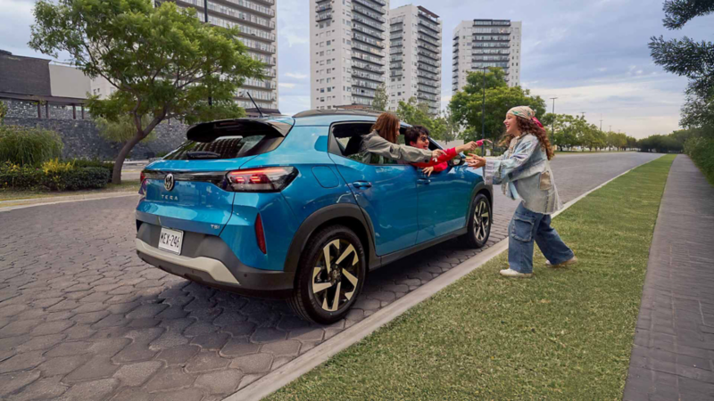 Mama e hija caminan hacia una camioneta Tiguan 2025 de Volkswagen, en color exterior blanco.