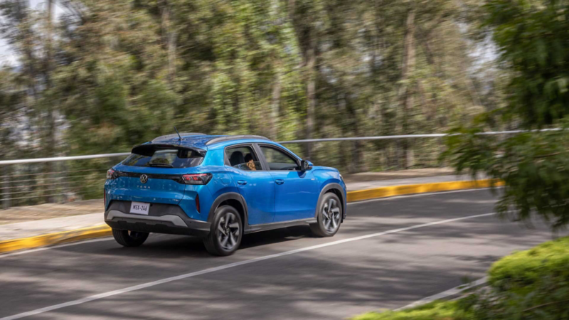 SUV Nivus de Volkswagen en color rojo sobre carretera con árboles.