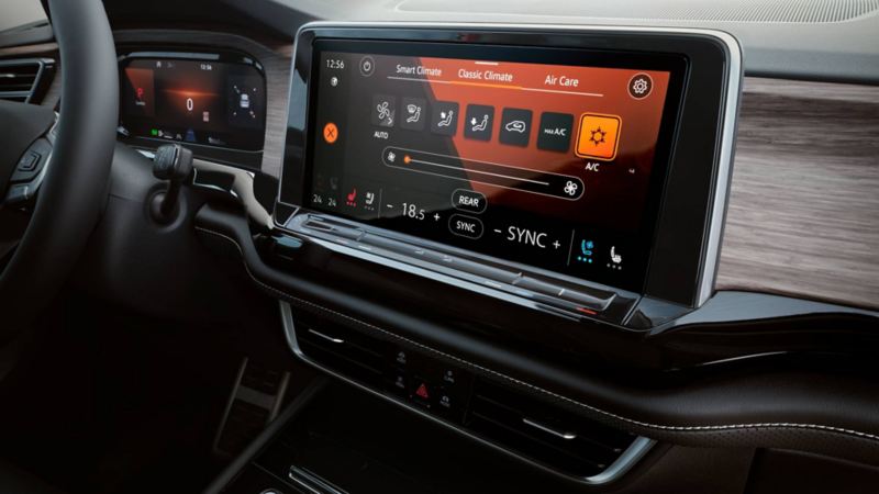 Copiloto de camioneta SUV Teramont 2022 elige aplicación al tocar la pantalla touch.