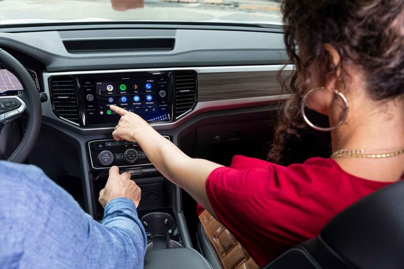 Copiloto de camioneta SUV Teramont 2022 elige aplicación al tocar la pantalla touch.