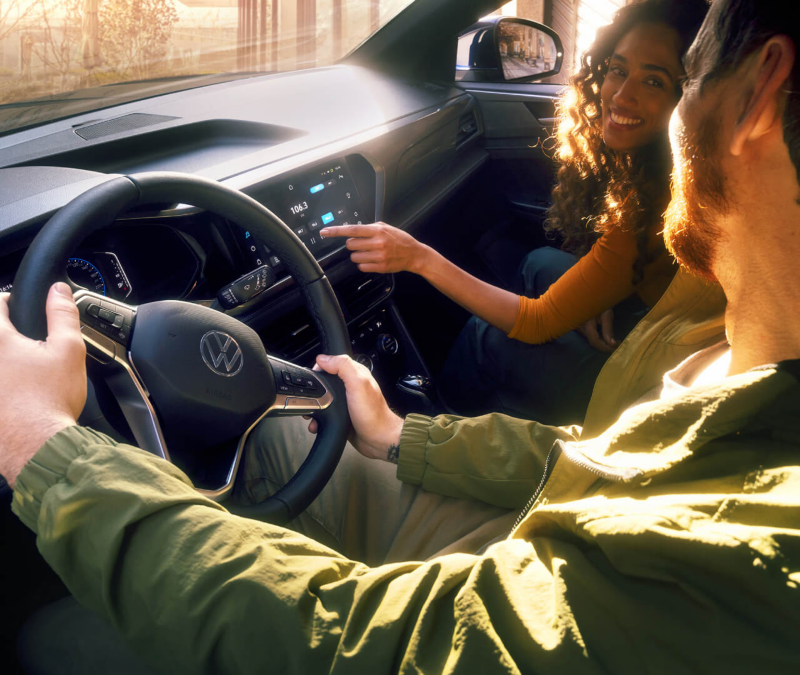 Imagen de la cabina interior de un VW con una mujer y un hombre realizando un test drive