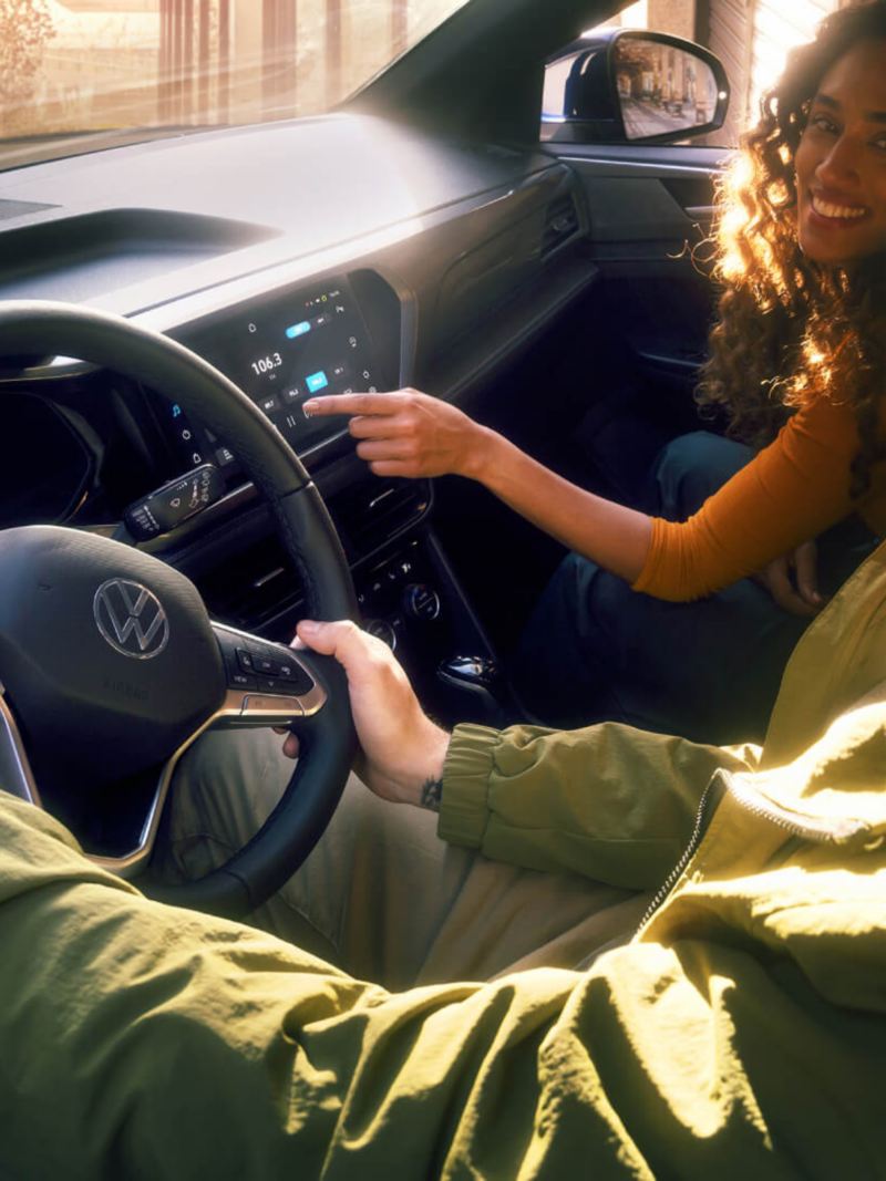 Imagen de la cabina interior de un VW con una mujer y un hombre realizando un test drive