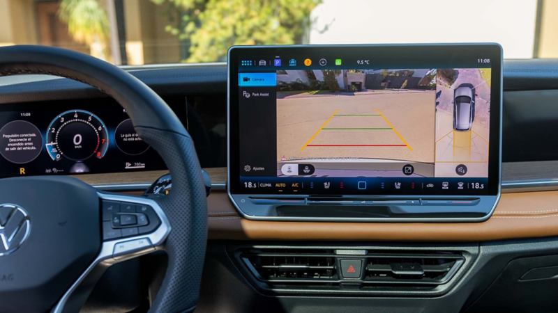 Interior de Tiguan 2025 con pantalla flotante que muestra la vista de la cámara 360. 
