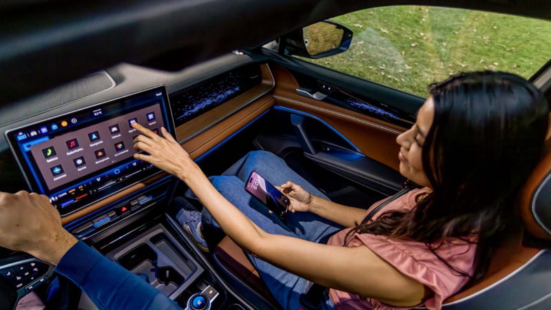 Mujer conecta su celular a Volkswagen Tiguan 2025 a través de Wireless App Connect. 