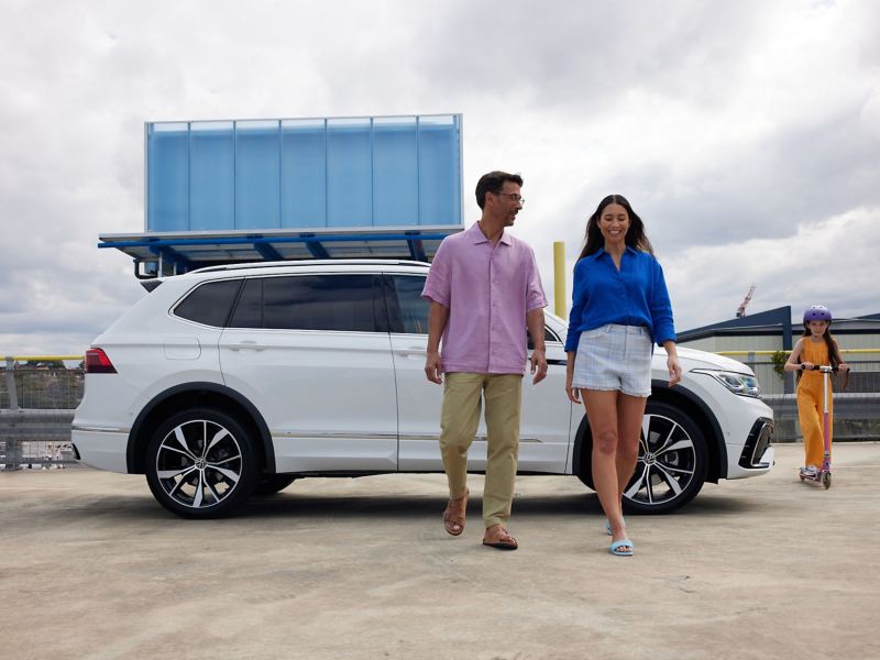 Family walking around Volkswagen Tiguan Allspace which is parked on the rooftop.