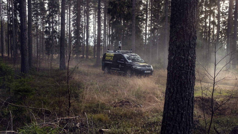 VW Caddy Maxi med Missing People emblem ute i skogen