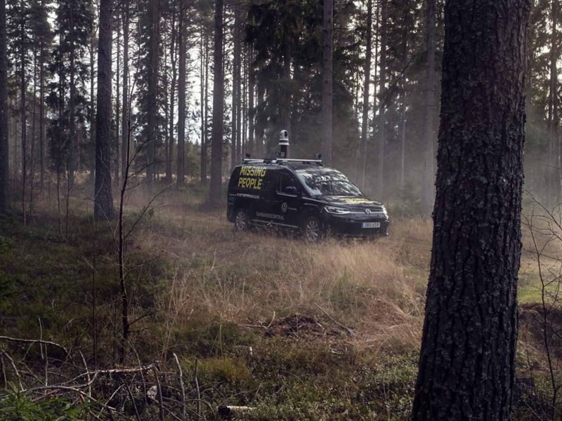 VW Caddy Maxi med Missing People emblem ute i skogen