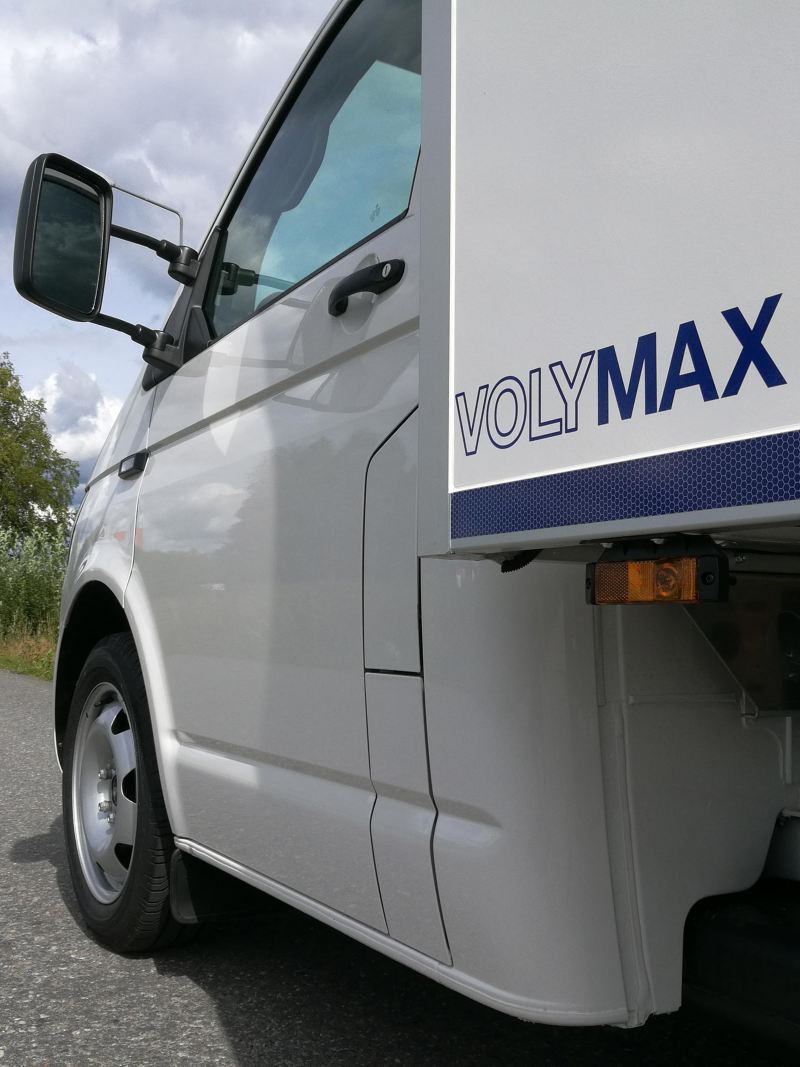 Vit VW Transporter VolyMax med logo från sidan